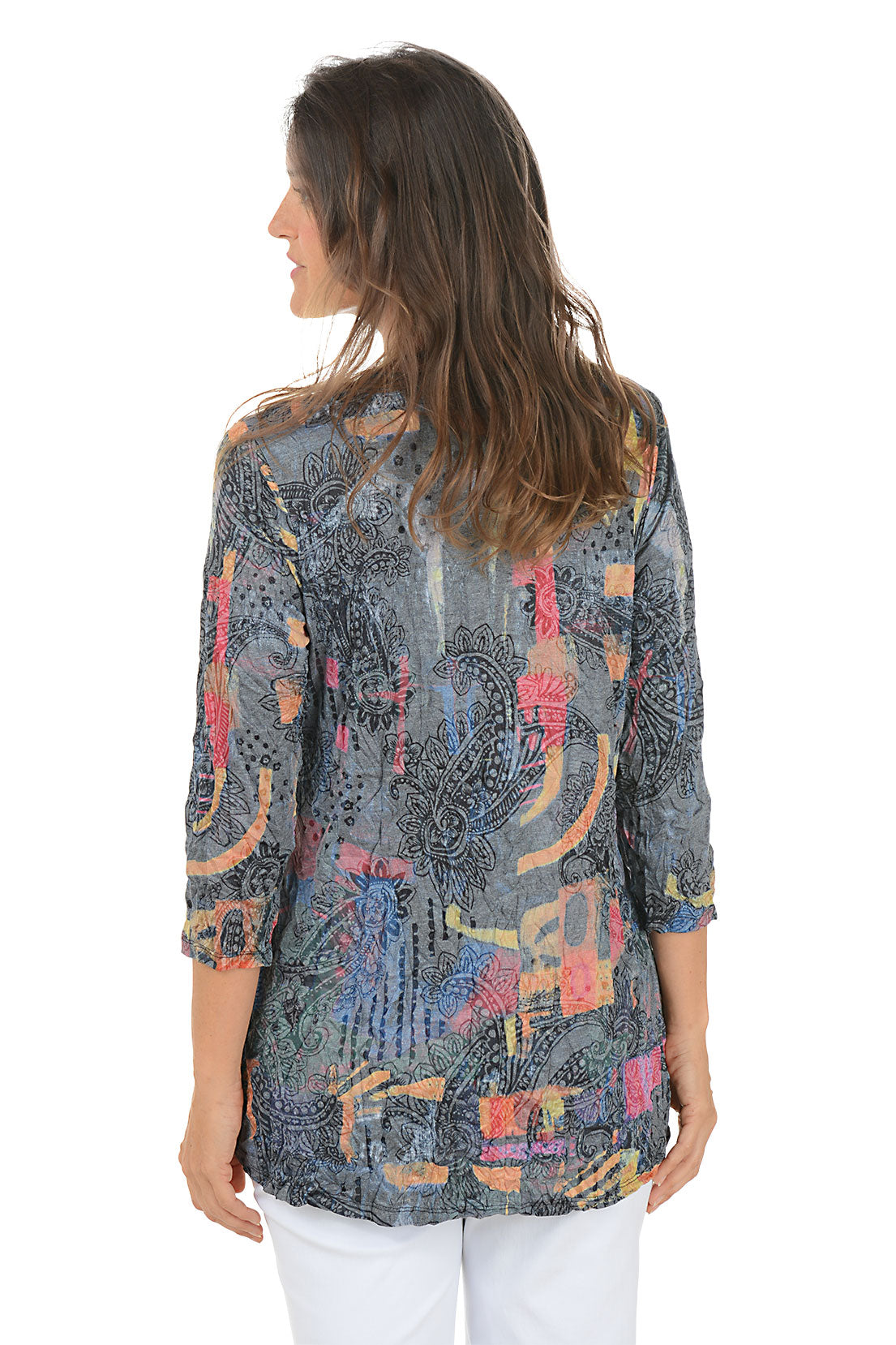 Woman wearing a patterned blouse with a white background. Back shot.