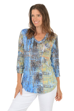 Woman wearing a colorful abstract patterned top on a white background.