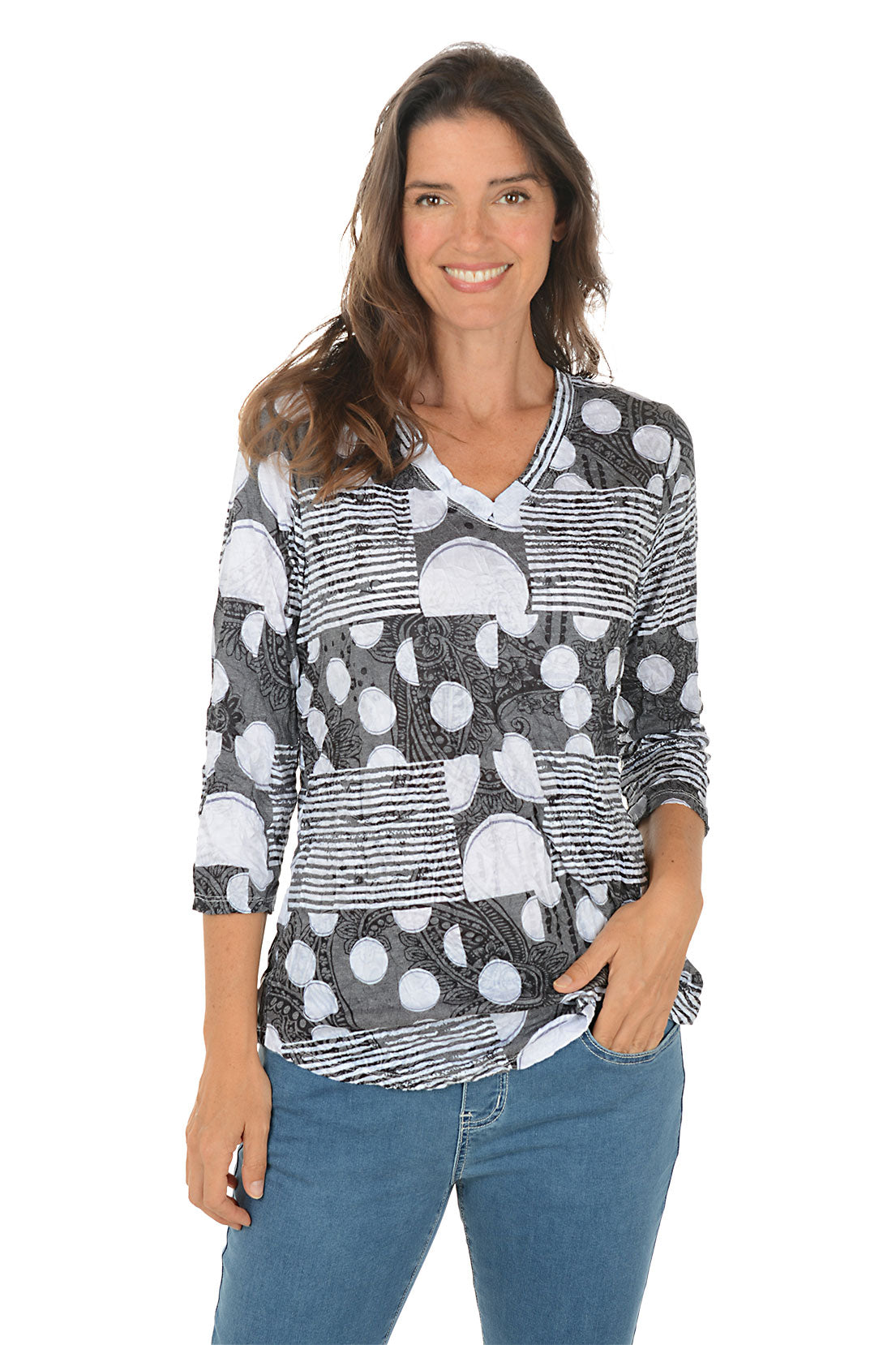 Woman wearing a patterned shirt and jeans on a white background.