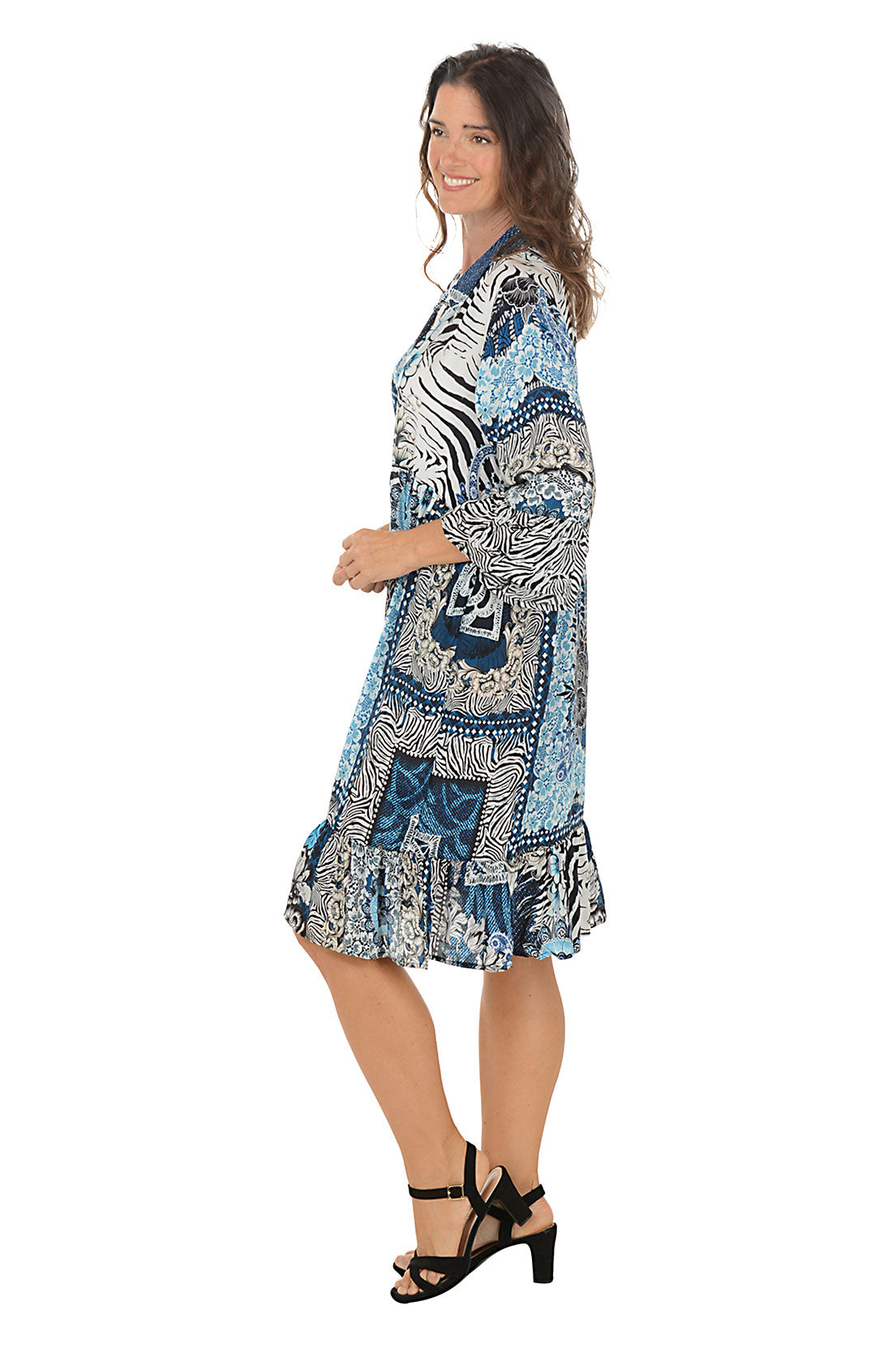 Woman wearing a patterned dress with zebra design on a white background. Side shot.