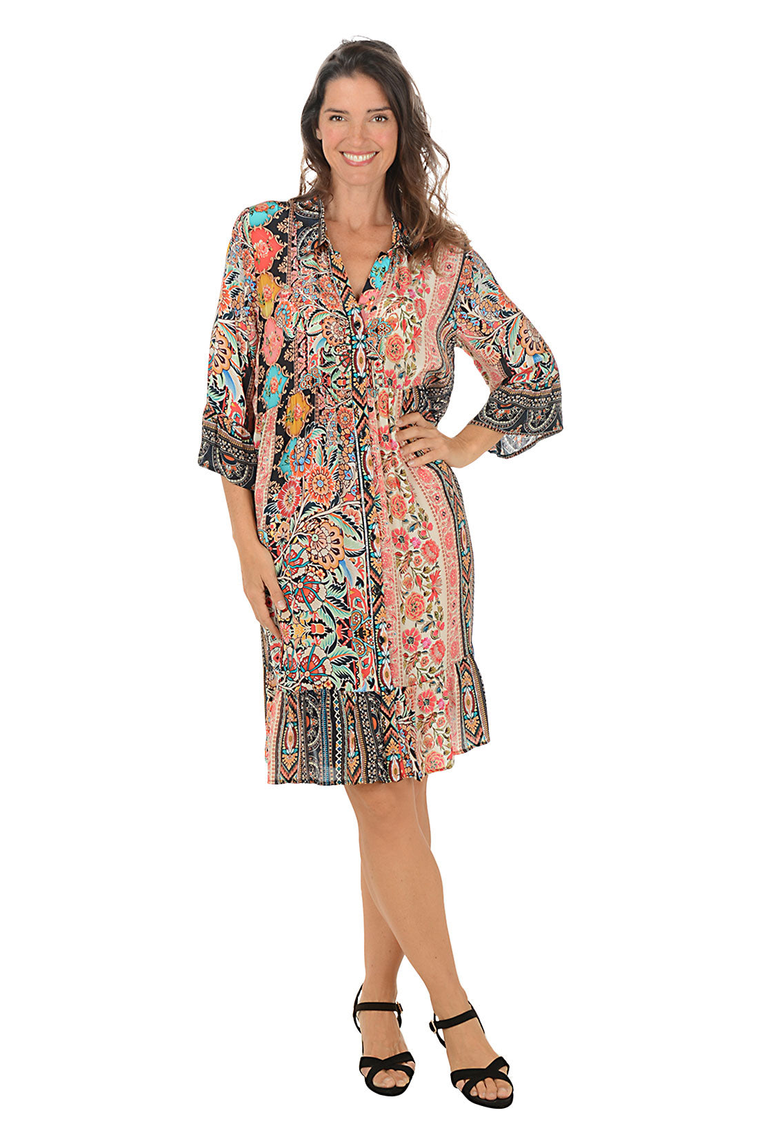 Woman wearing a colorful patterned dress on a white background.