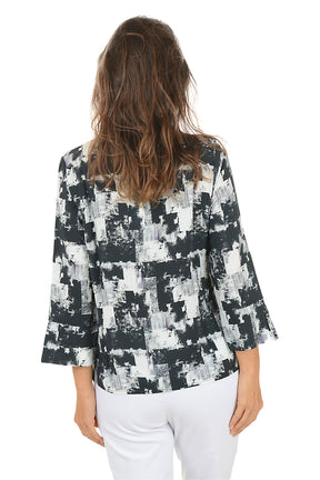 Woman wearing a patterned blouse and white pants on a white background. Back shot.