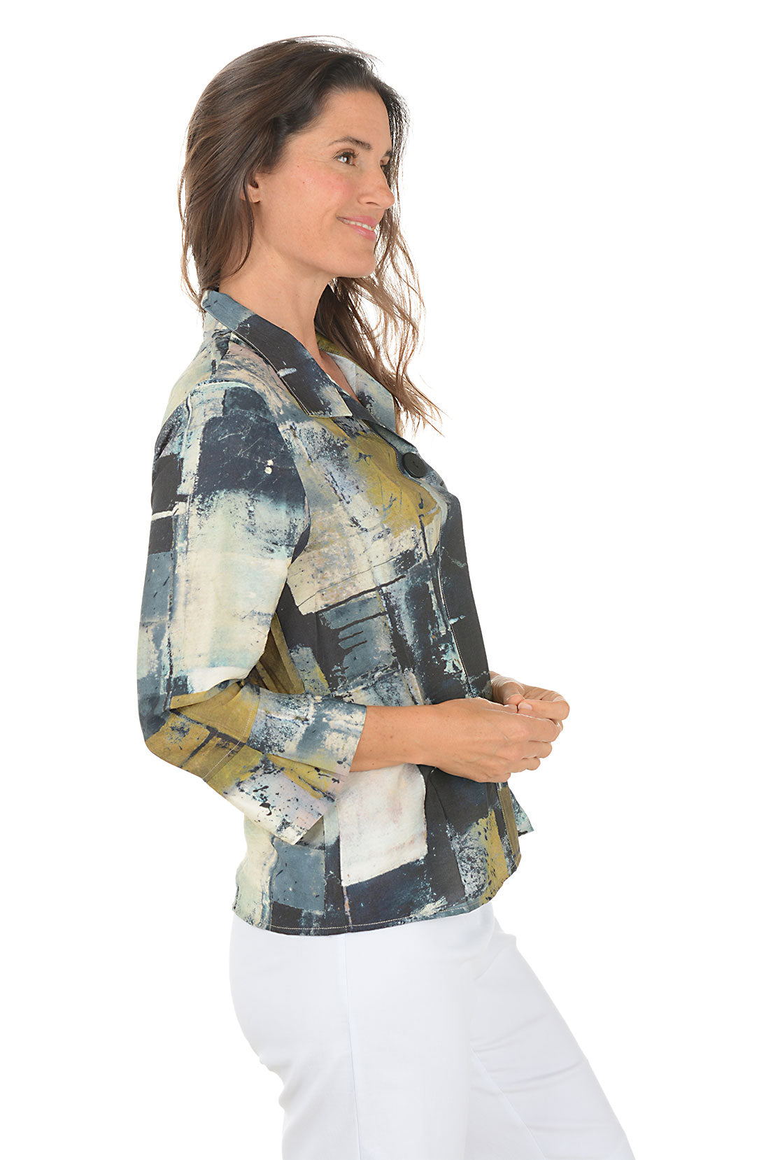 Woman wearing a colorful abstract patterned blouse on a white background. Side shot.