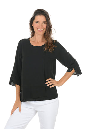Woman wearing a black blouse with sheer sleeves on a white background.