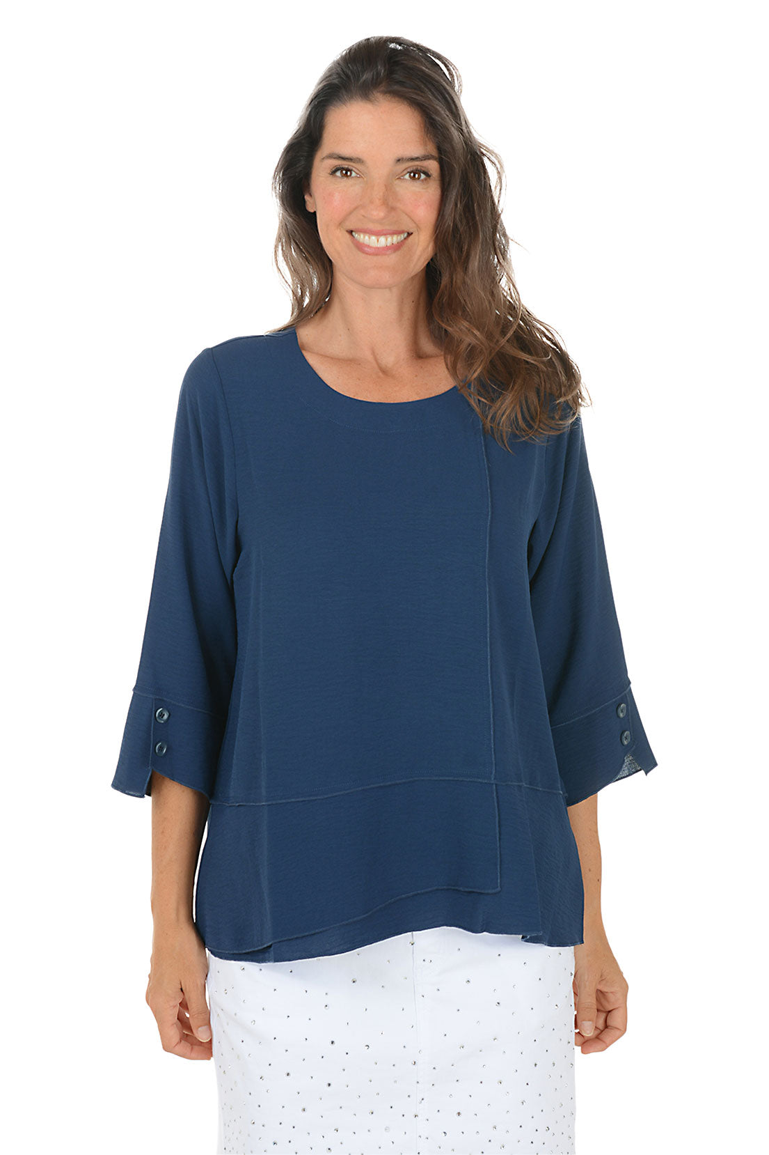 Woman wearing a navy blouse with sheer sleeves on a white background.