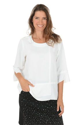 Woman wearing a white blouse with sheer sleeves on a white background.
