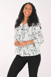 Woman wearing a white blouse with black line art design on a white background