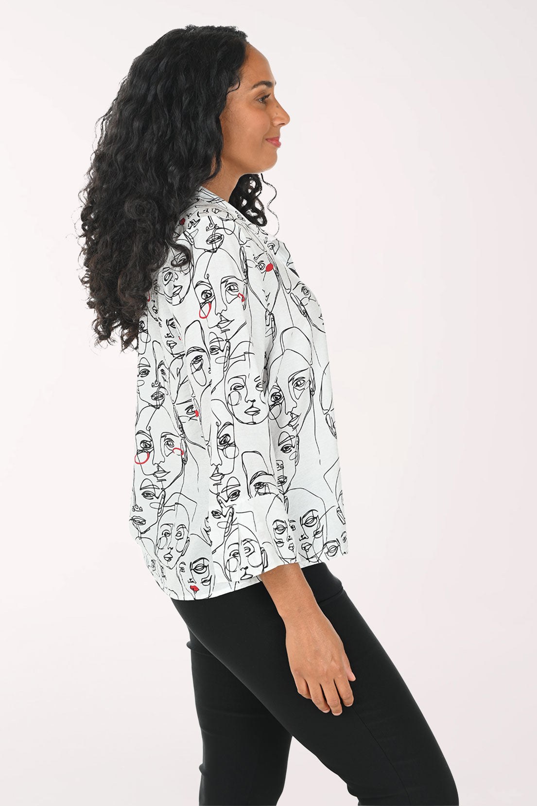 Woman wearing a white blouse with black line art design on a white background