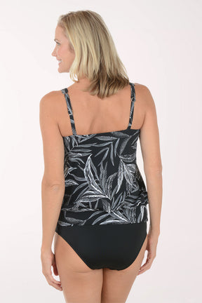 Woman wearing a black and white leaf-patterned tankini on a white background. Back shot.
