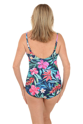 Woman wearing a colorful floral swimsuit on a white background. Back shot.