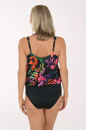 Woman wearing a colorful floral tankini top and black bottoms on a white background