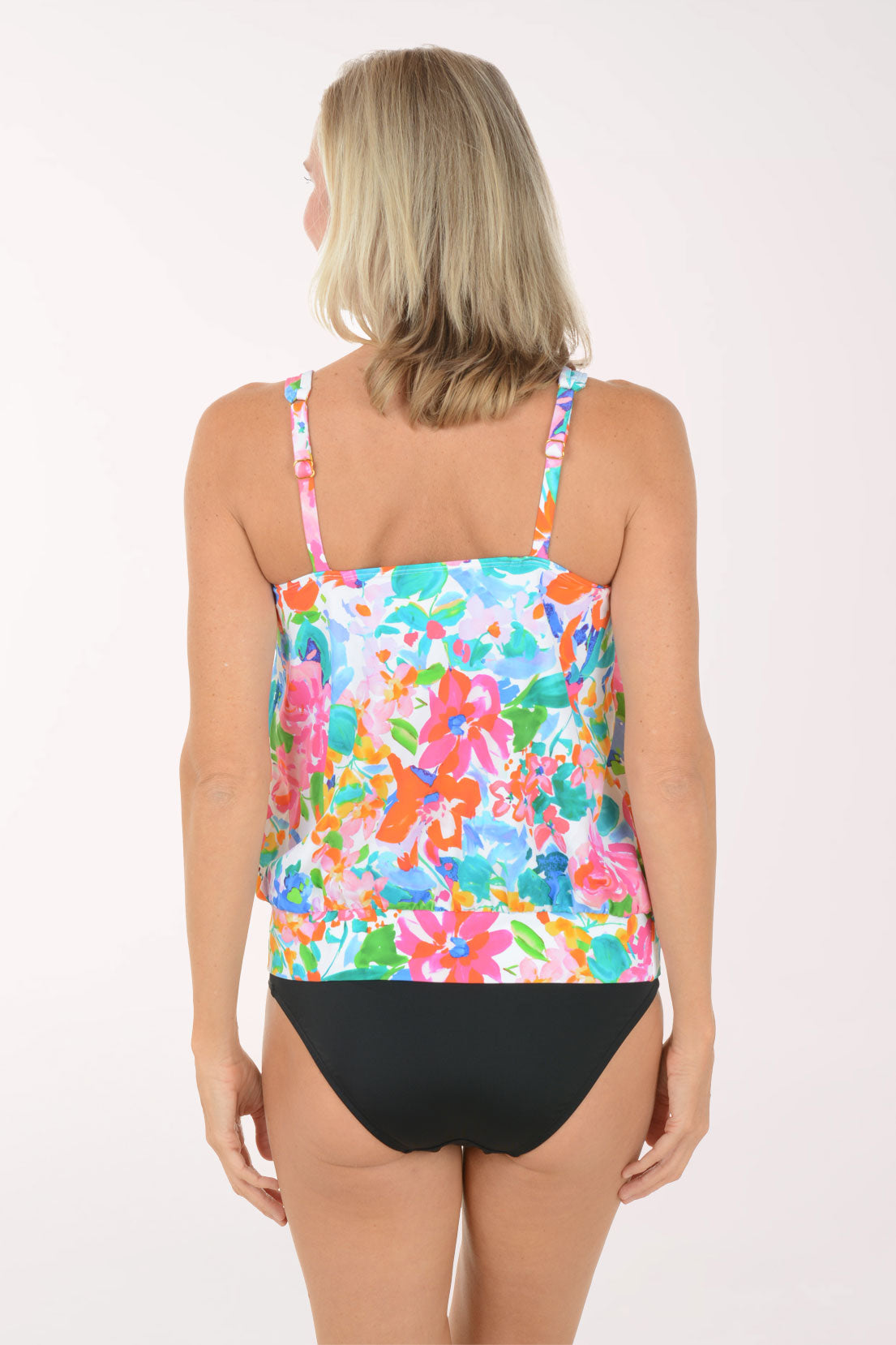 Woman wearing a colorful floral tankini set on a white background. Back shot.