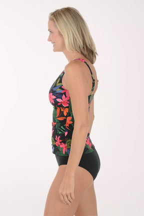 Woman wearing a colorful floral tankini top and black bottoms on a white background. Side shot.