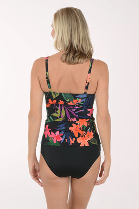 Woman wearing a colorful floral tankini top and black bottoms on a white background. Back shot.