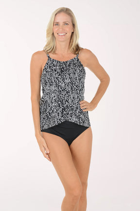 Woman wearing a black and white patterned tankini set on a white background