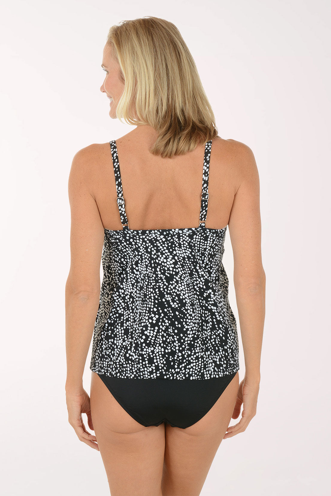 Woman wearing a black and white patterned tankini top on a white background