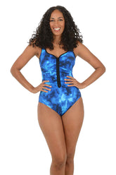 Woman wearing a blue tie-dye swimsuit with a black zipper on a white background.