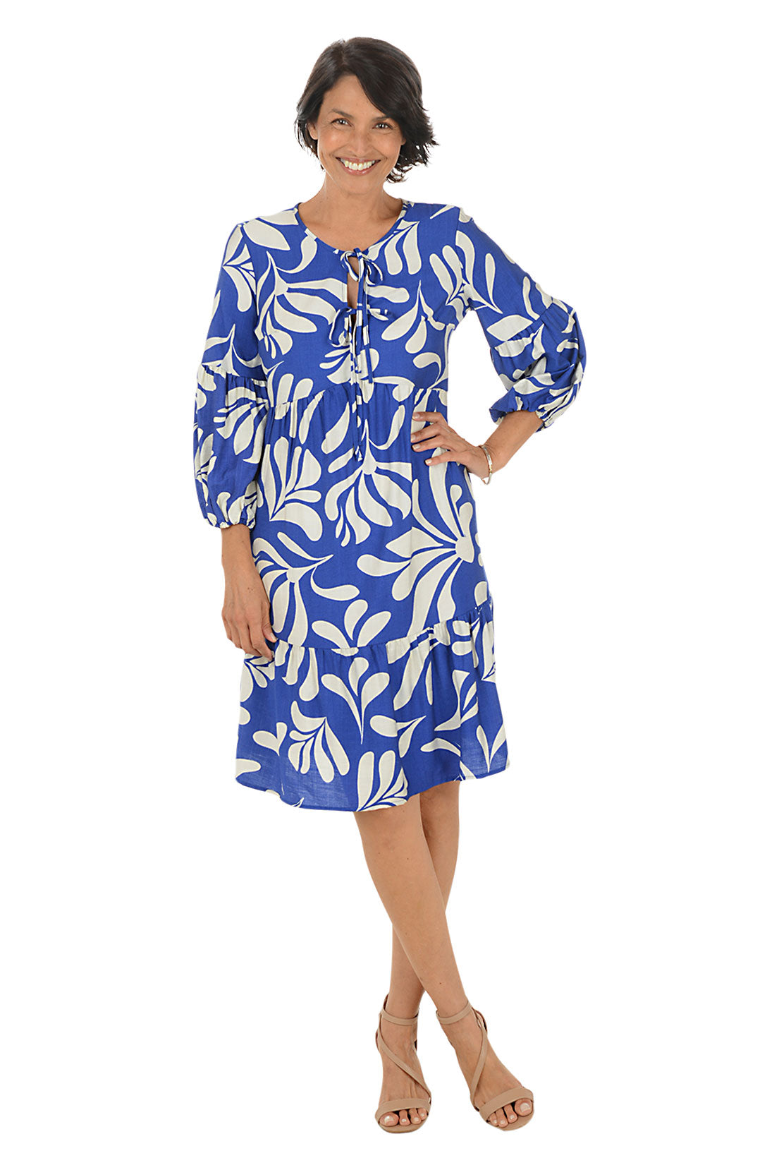 Woman wearing a blue and white patterned dress on a white background.