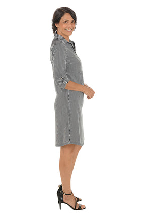 Woman wearing a black and white stripe dress on a white background. Side shot.
