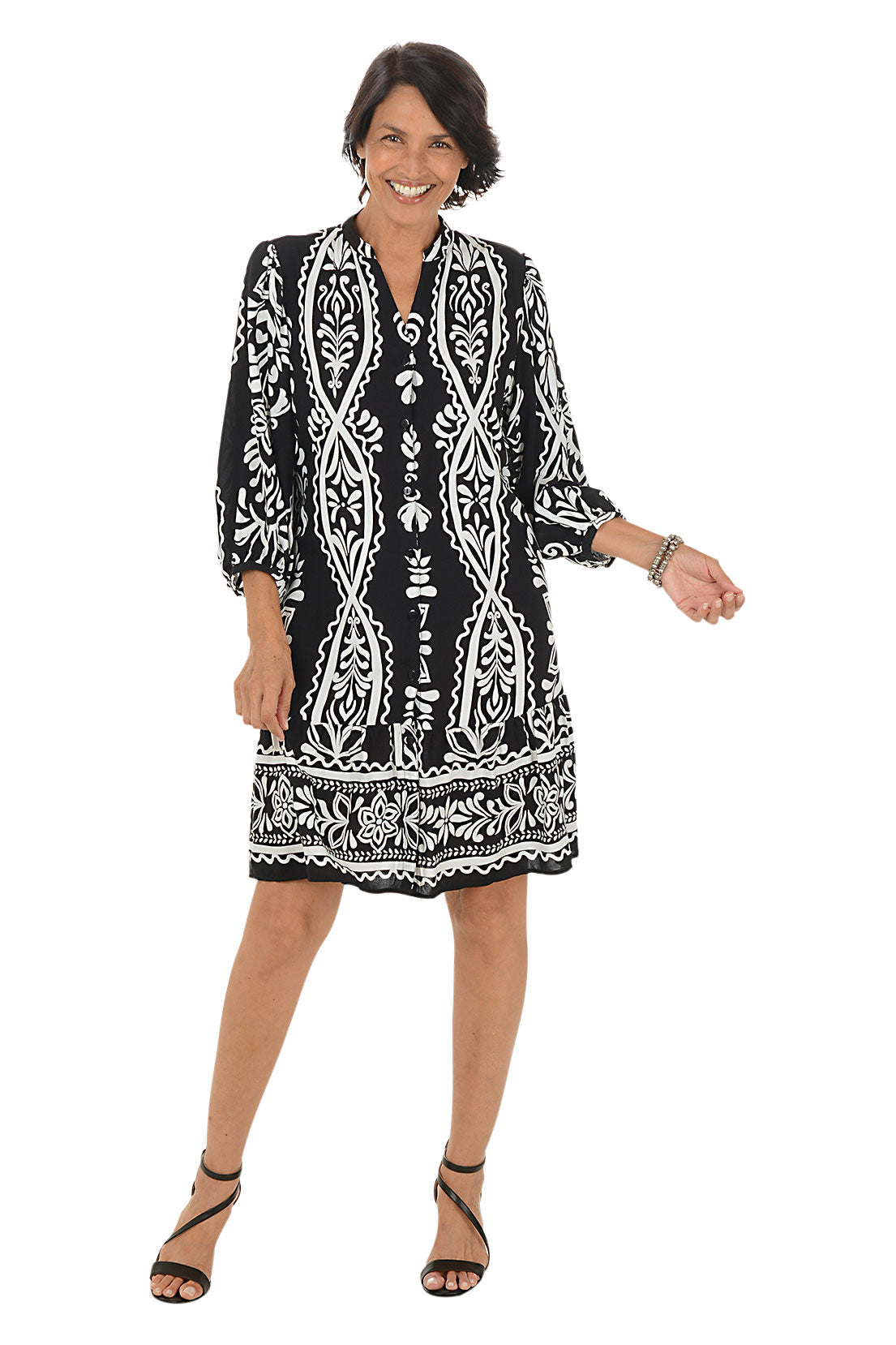 Woman wearing a black and white patterned dress on a white background.