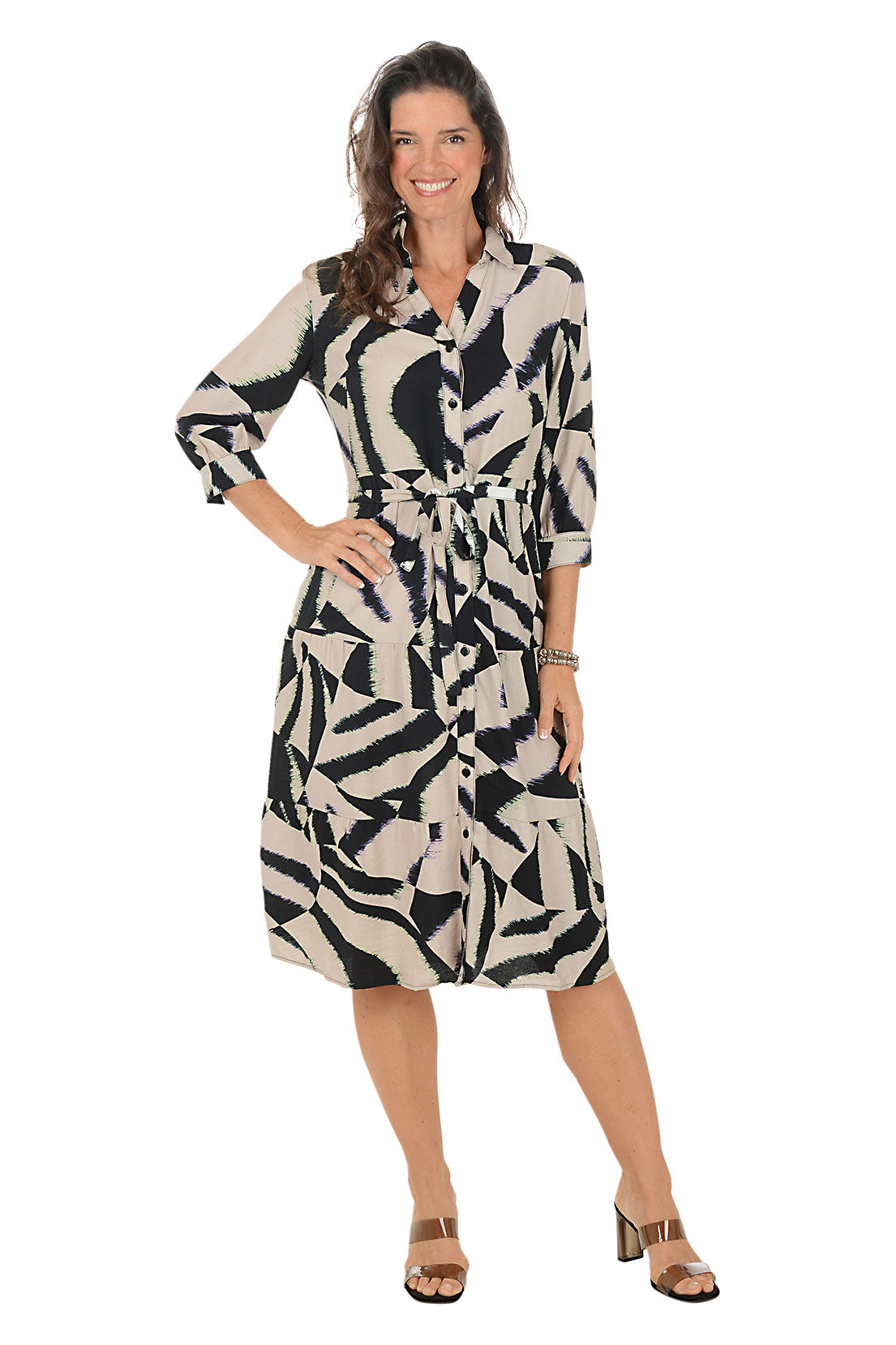 Woman wearing a black and brown patterned dress on a white background.
