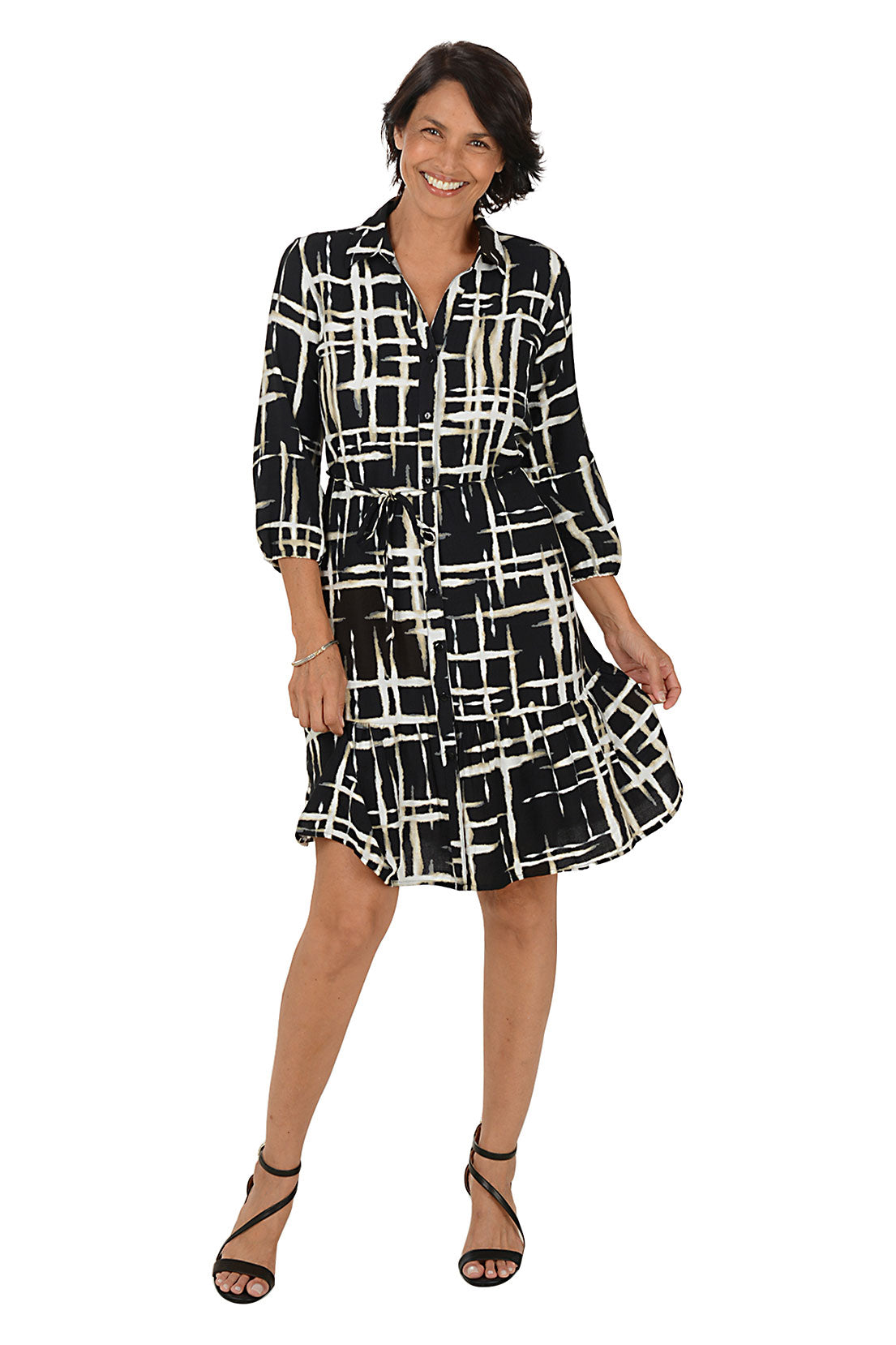 Woman wearing a black and white patterned dress on a white background. Second front shot.