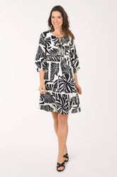 Woman wearing a black and white patterned dress on a white background