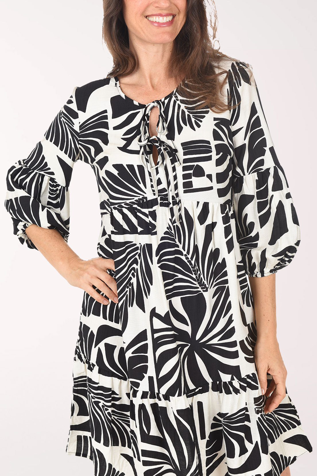 Woman wearing a black and white patterned dress on a white background