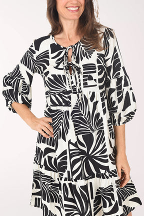 Woman wearing a black and white patterned dress on a white background