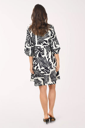 Woman wearing a black and white patterned dress on a white background