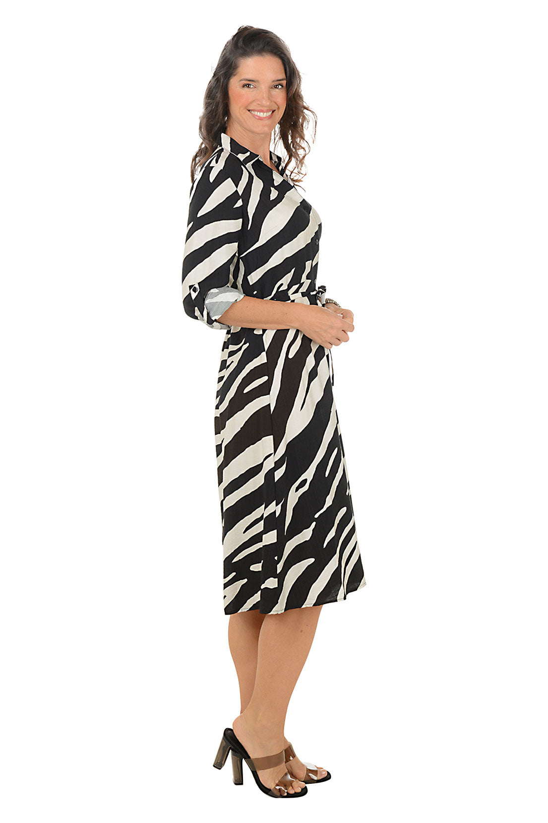 Woman wearing a zebra print dress on a white background. Side shot.