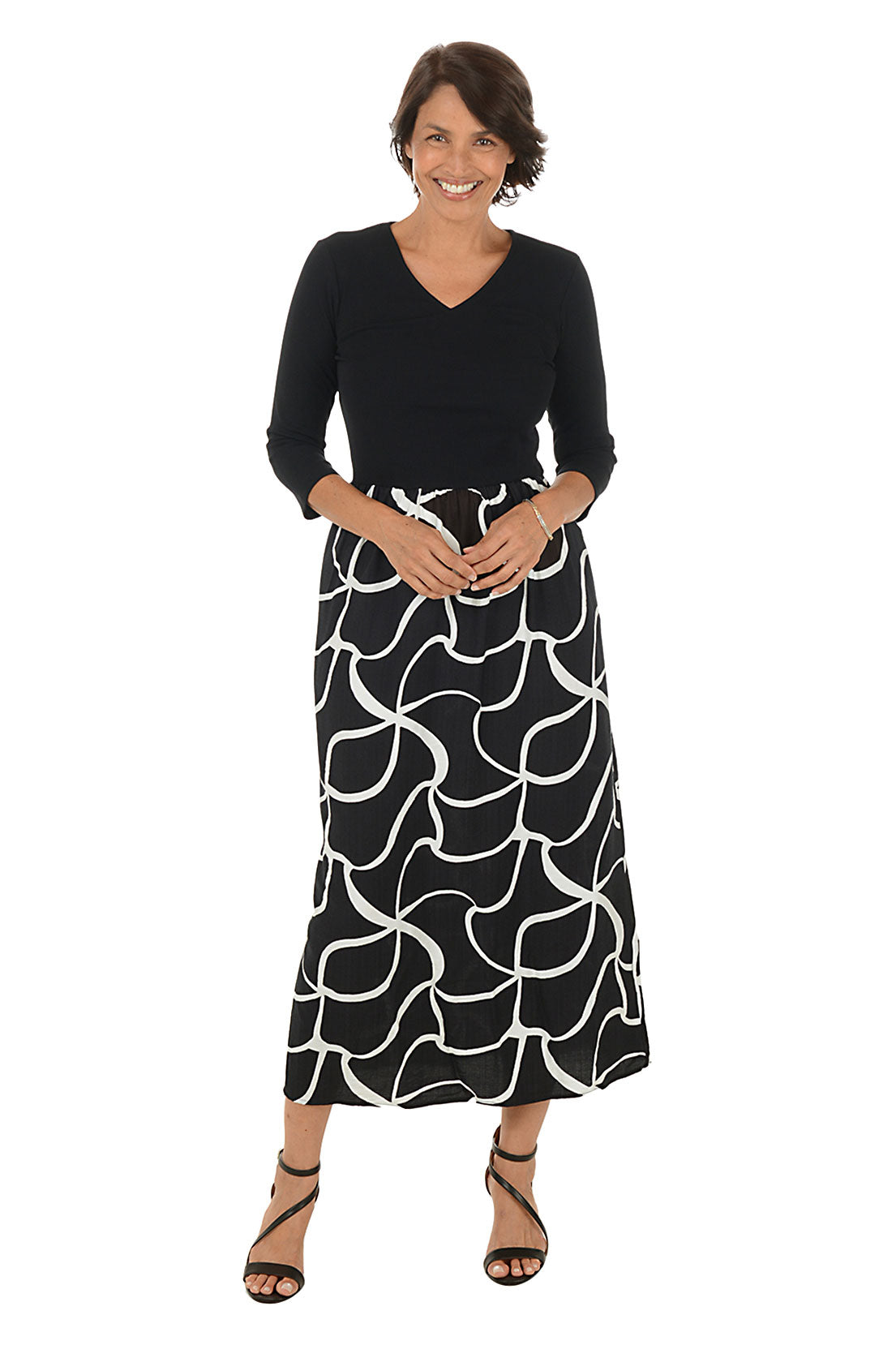 Woman wearing a 3/4 sleeve black and white patterned maxi dress on a white background.