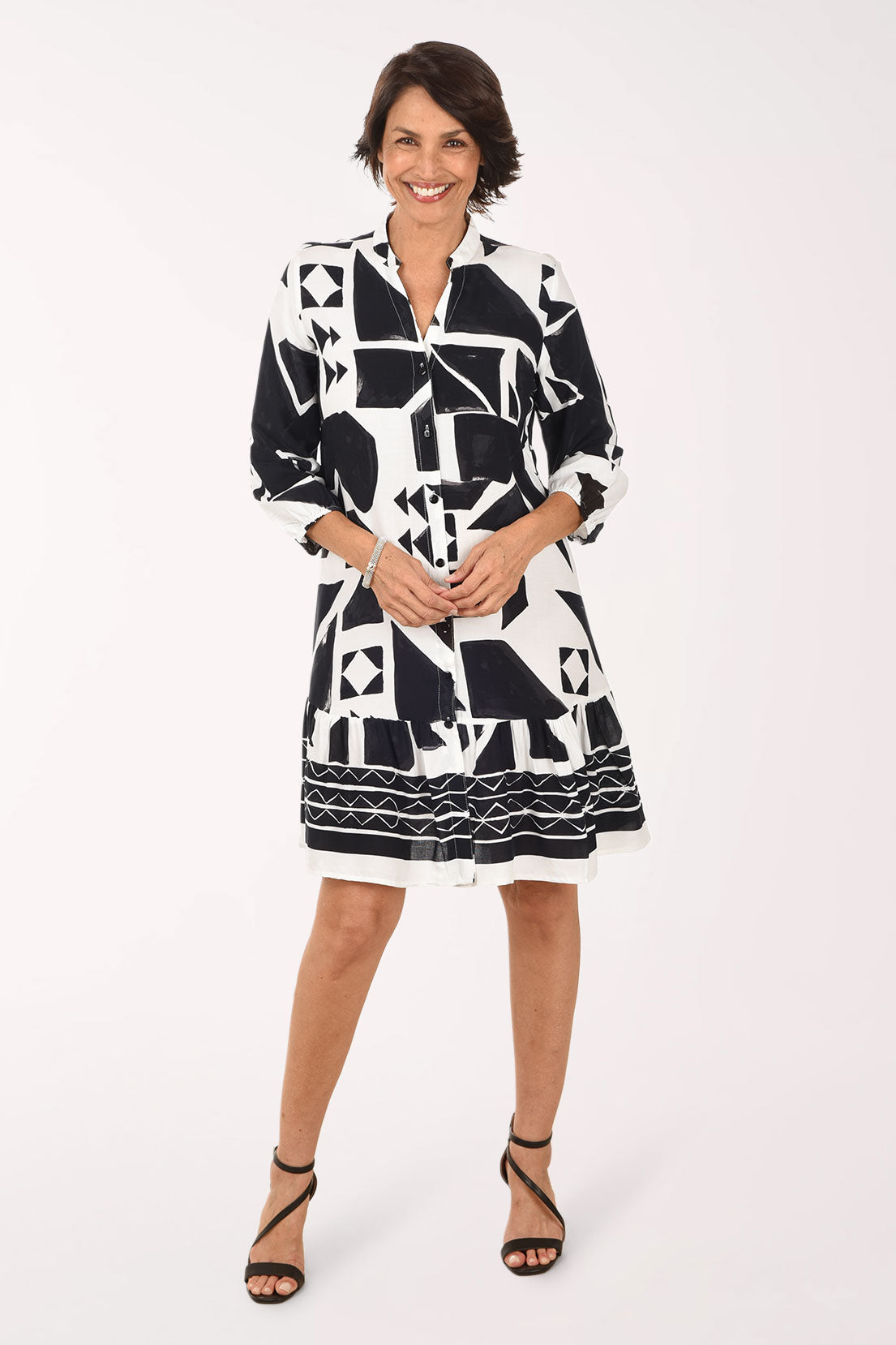 Woman wearing a black and white patterned dress on a white background