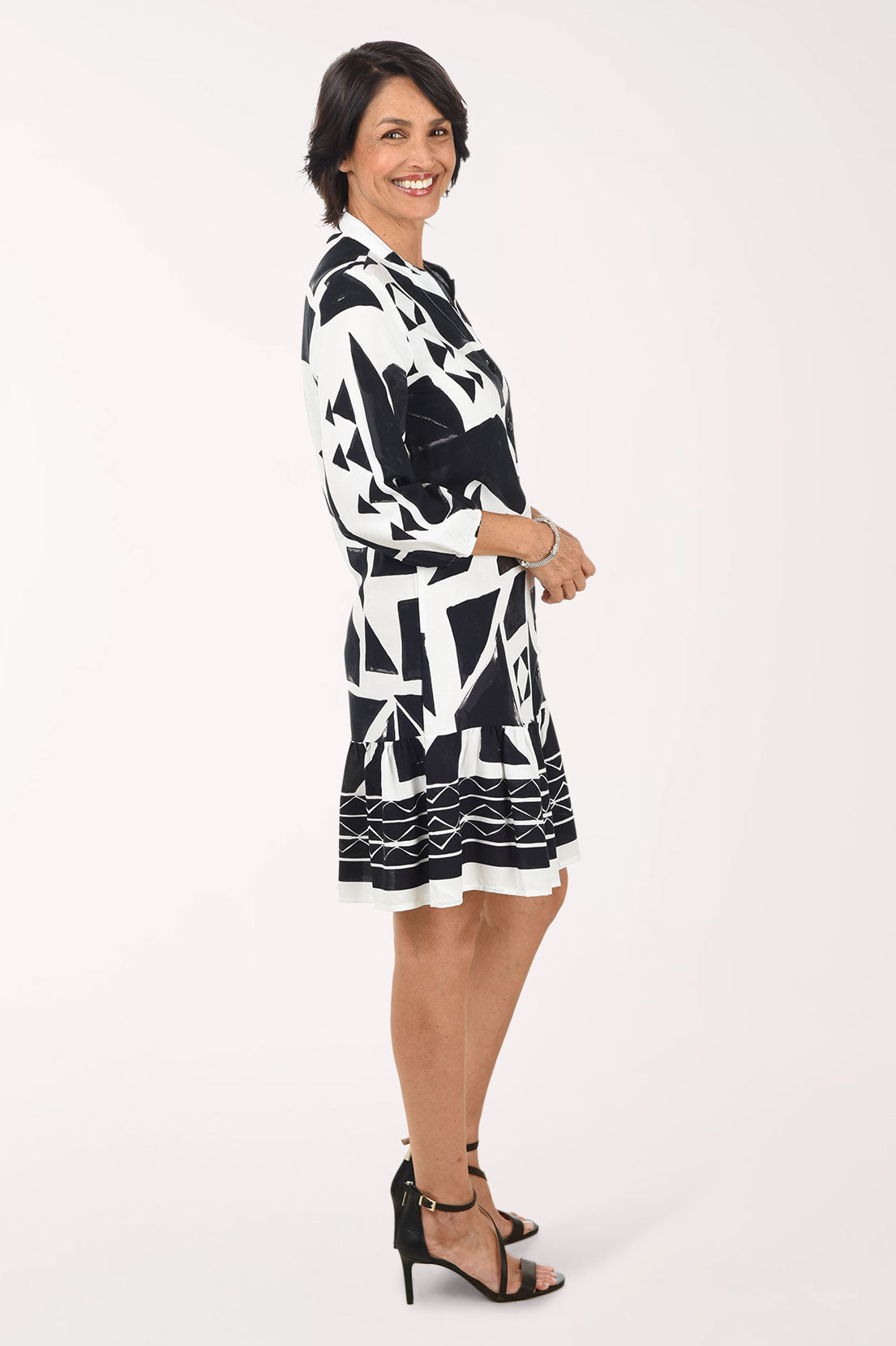 Woman wearing a black and white patterned dress on a white background