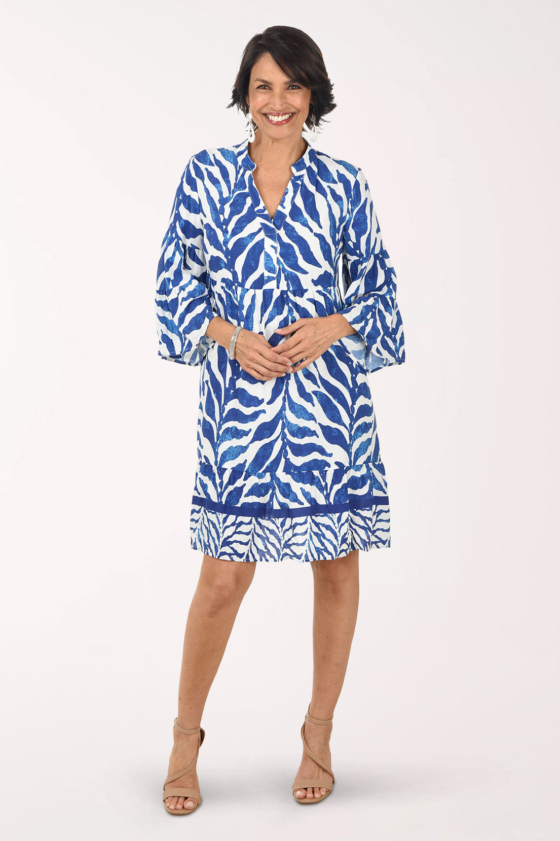 Woman wearing a blue and white patterned dress on a white background
