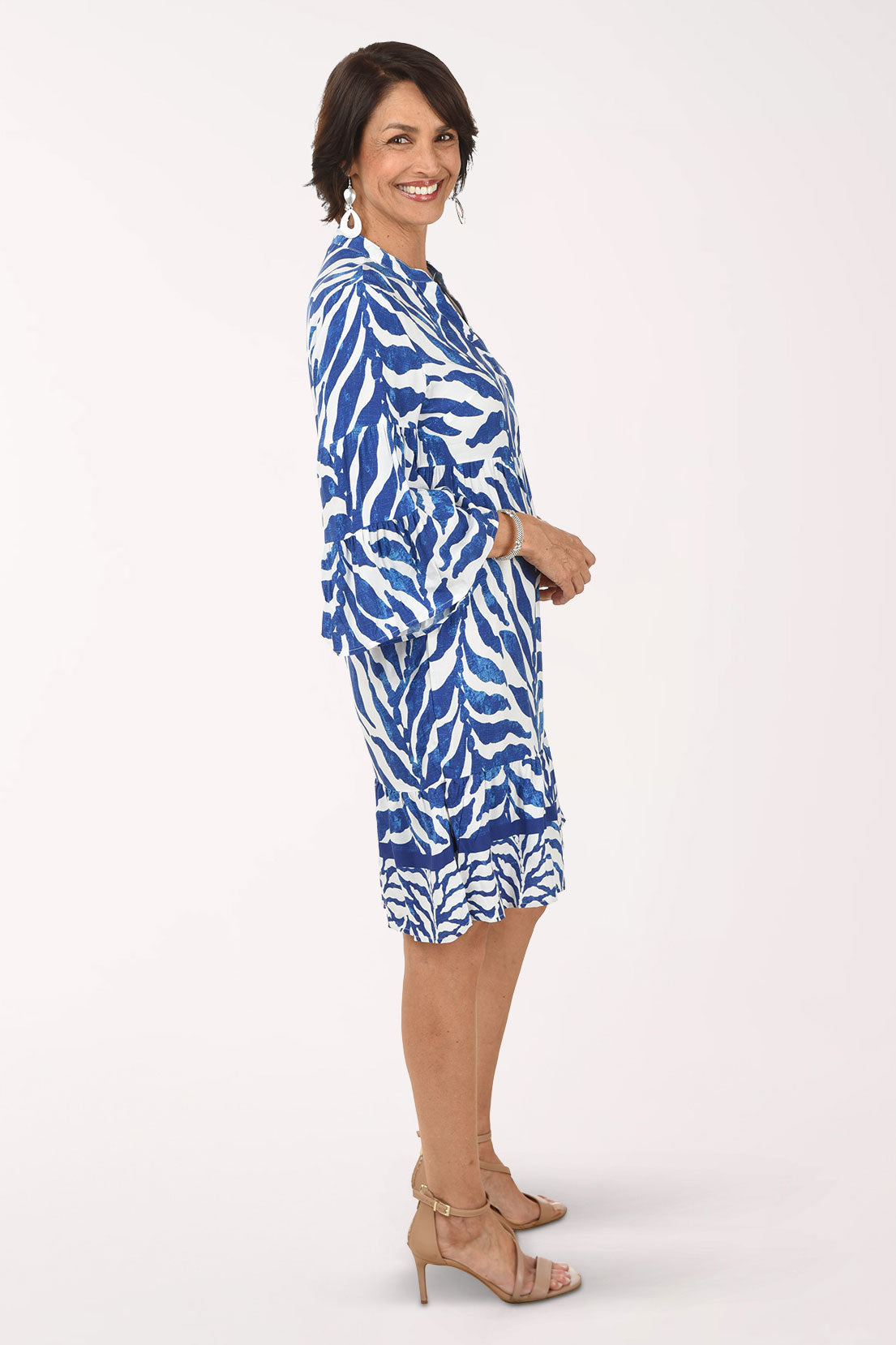Woman wearing a blue and white patterned dress on a white background