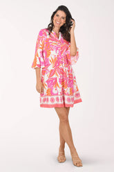 Woman wearing a colorful dress with a floral pattern on a white background