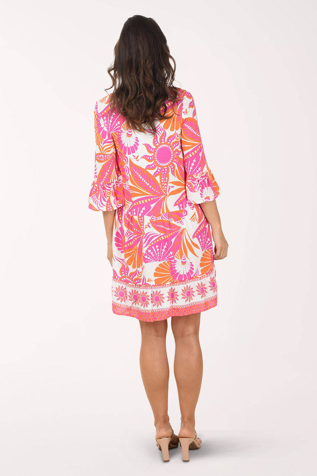 Woman wearing a colorful dress with a floral pattern on a white background