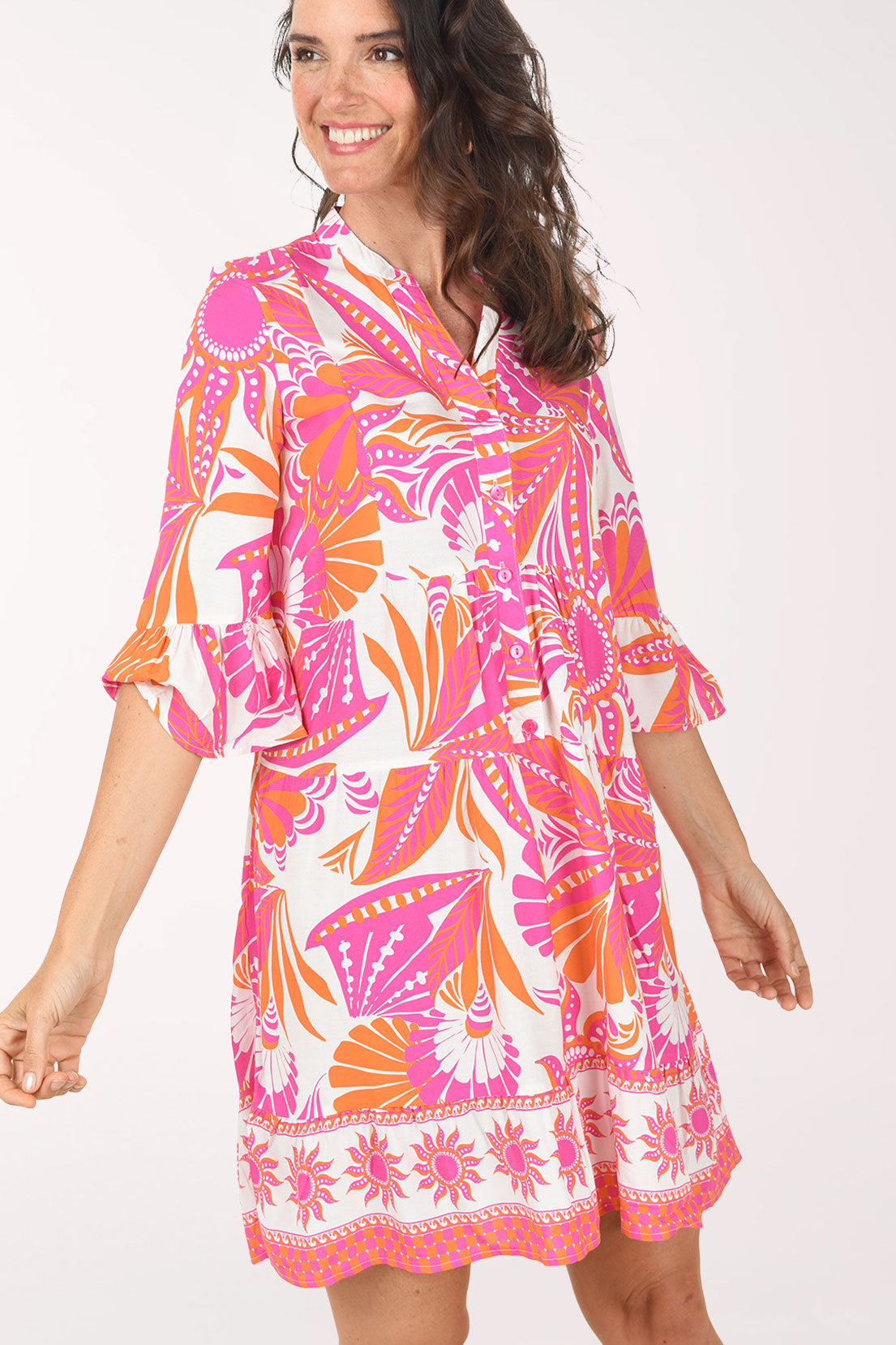 Woman wearing a colorful dress with a floral pattern on a white background