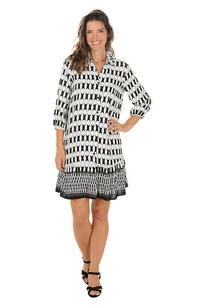 Woman wearing a 3/4 sleeved black and white patterned dress on a white background.