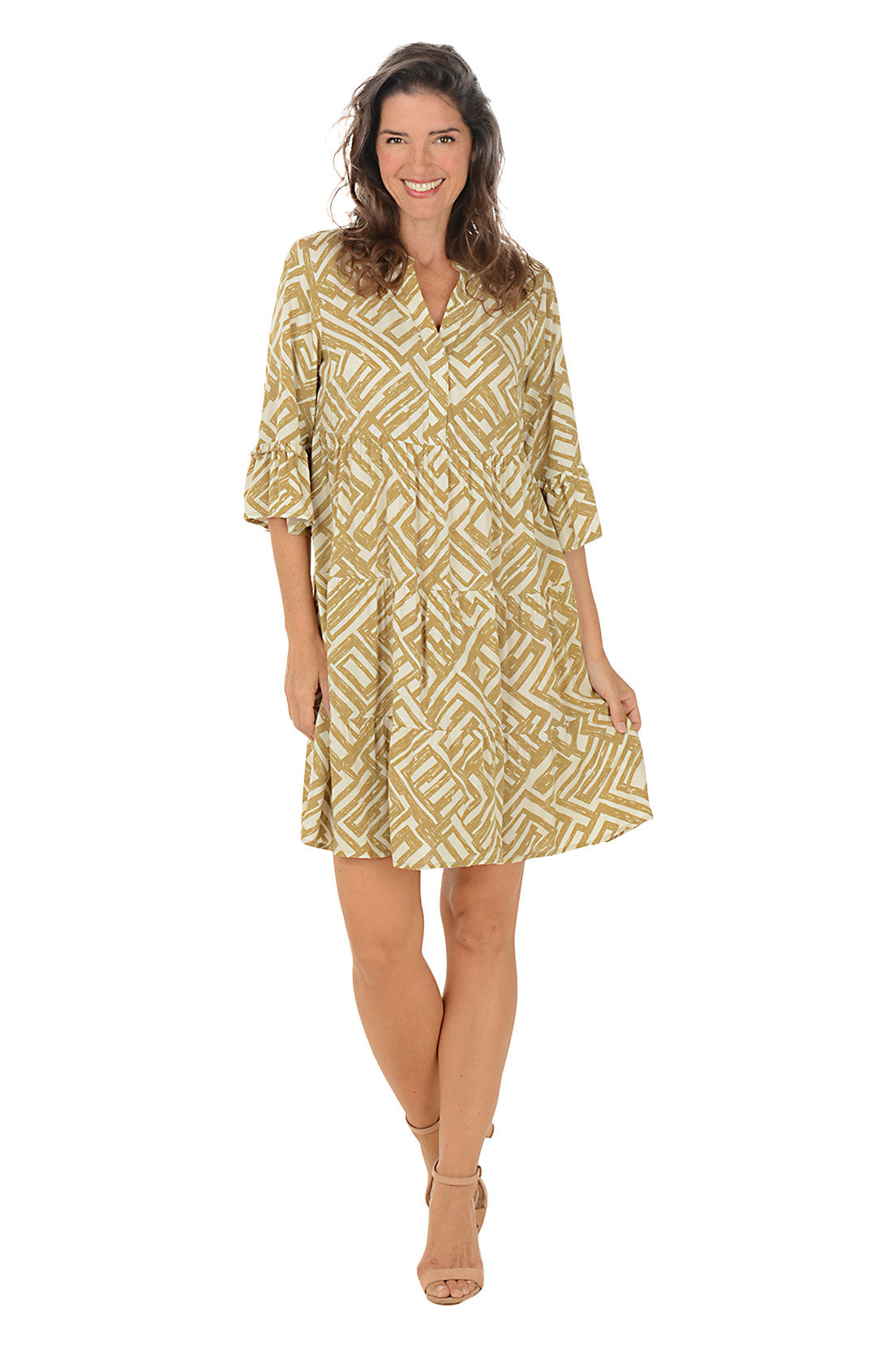 Woman wearing a gold and white patterned dress on a white background.