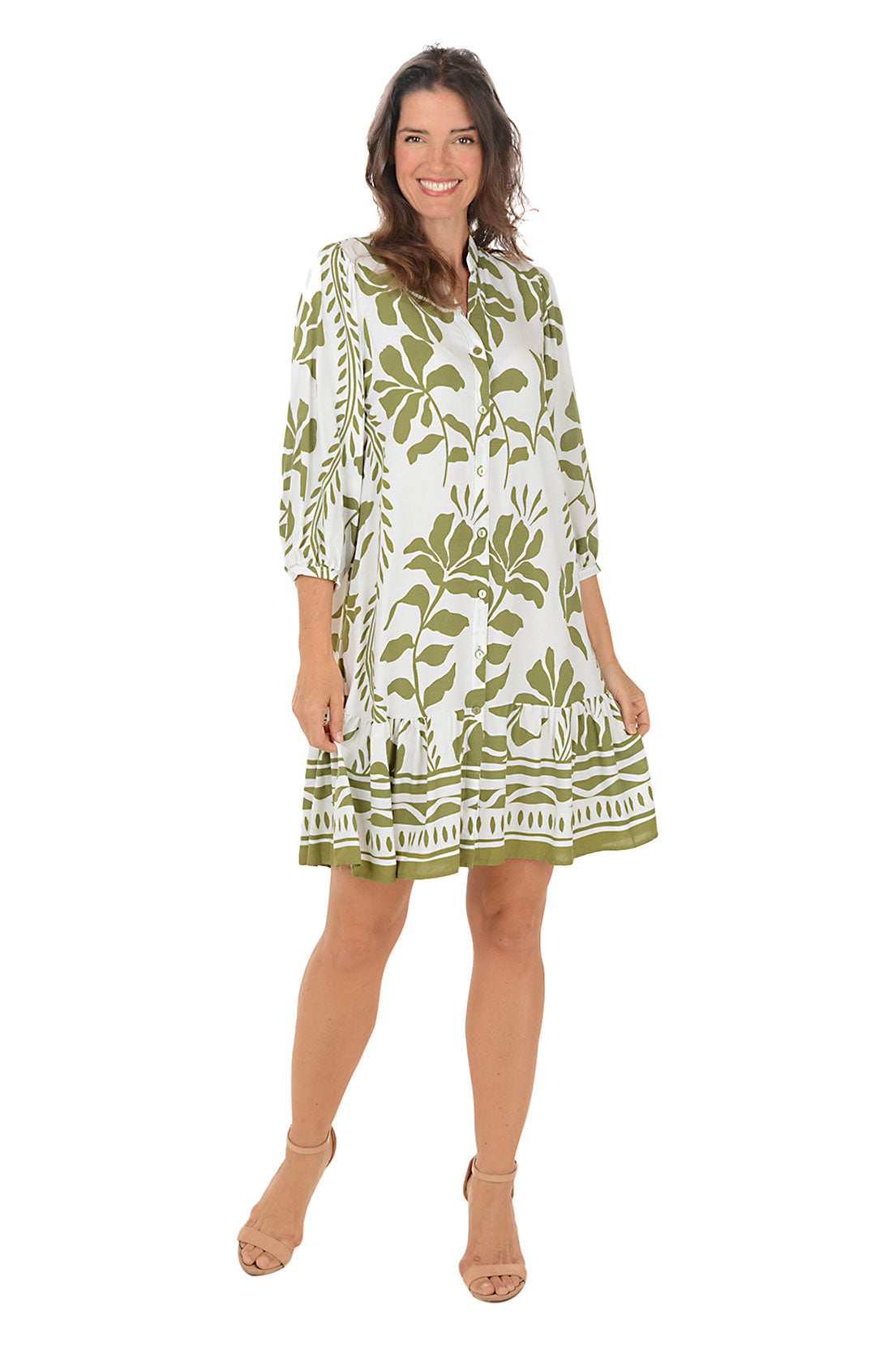 Woman wearing a 3/4 sleeved green and white floral vine patterned dress on a white background.