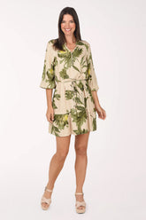 Model wearing the Mlle Gabrielle Green Blossom Belted Dress, a sand dress with olive and yellow-green botanical blossoms, front view