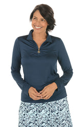 Woman wearing a navy long-sleeve top with a floral skirt on a white background.