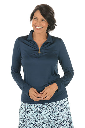 Woman wearing a navy long-sleeve top with a floral skirt on a white background.
