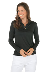 Woman wearing a black long-sleeve top and white pants on a white background.
