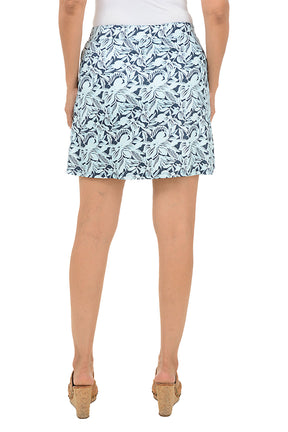 Woman wearing a patterned skirt on a white background. Back shot.