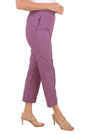A woman wearing a cropped trouser pant in a pink multi floral print. Side shot.