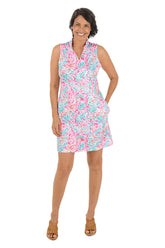 Woman wearing a colorful sleeveless dress on a white background.