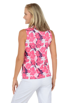 A woman wearing a sleeveless polo activewear top in a pink multi floral pattern and a navy contrast collar. Back shot.